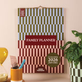 Family planner with checkered design on a wall, with a grid for 2026 - boho aesthetic