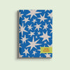 A bright blue A5 diary cover for 2026, featuring a scattered pattern of light beige stars with varying sizes and points. A rectangular yellow-green box on the bottom right says "2026 DIARY" in black text.