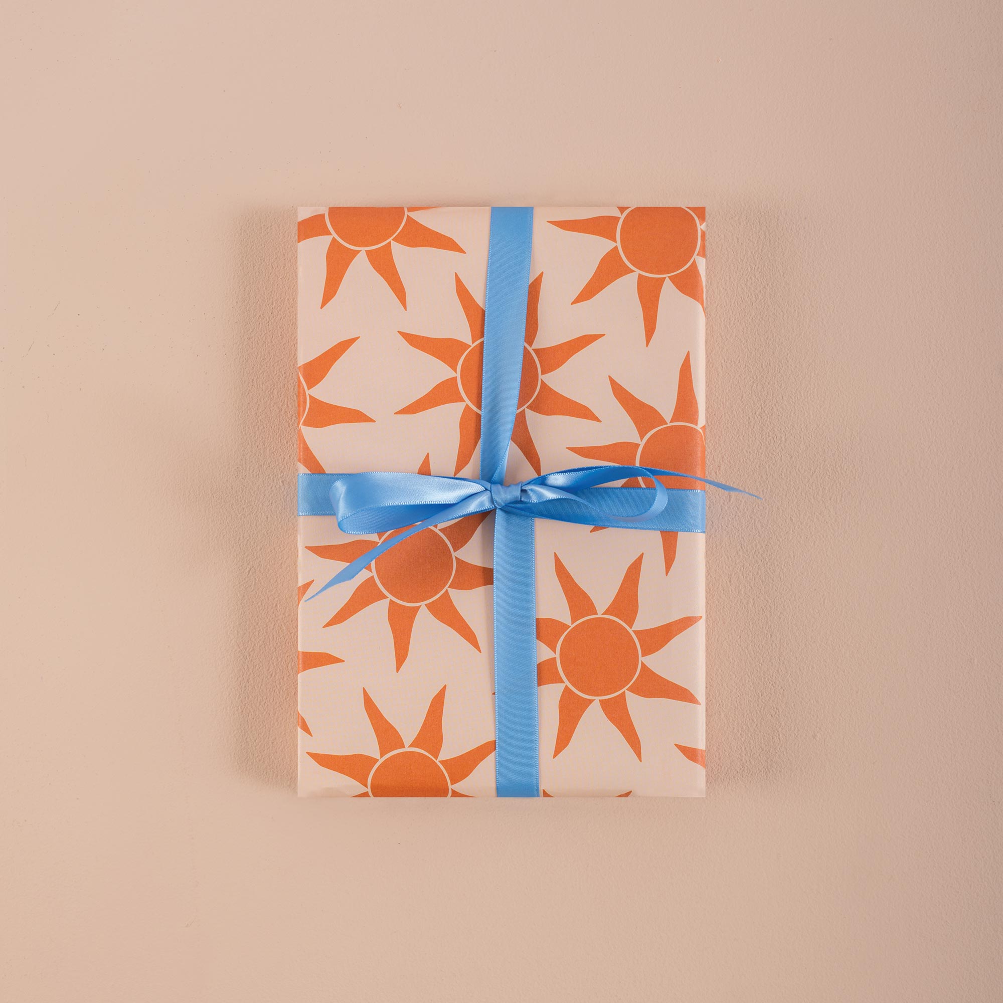 Good Tuesday's vibrant Sunbeam recycled wrapping paper, beautifully displayed as eco-friendly gift wrap, designed and proudly made in the UK.