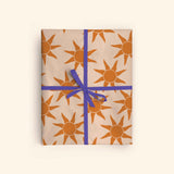 Good Tuesday's vibrant Sunbeam recycled wrapping paper, beautifully displayed as eco-friendly gift wrap, designed and proudly made in the UK.