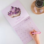 2026 Crystals calendar. 12 month Planner. Image shows calendar open on month of February with an Amethyst crystal design.