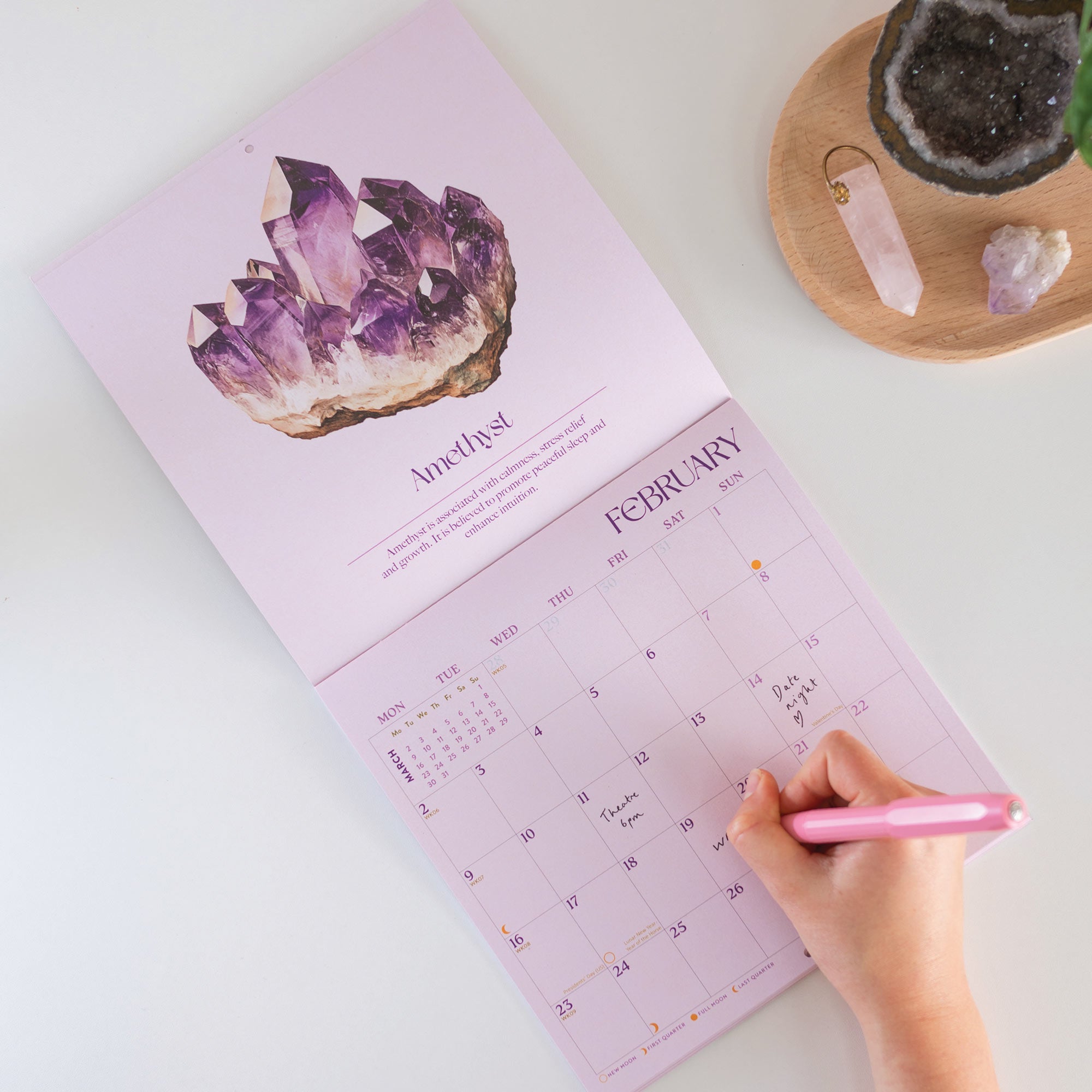 2026 Crystals calendar. 12 month Planner. Image shows calendar open on month of February with an Amethyst crystal design.