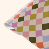 Close-up detail of Good Tuesday's Harlequin wrapping paper, showcasing the intricate geometric pattern and vibrant colors on our sustainable gift wrap.