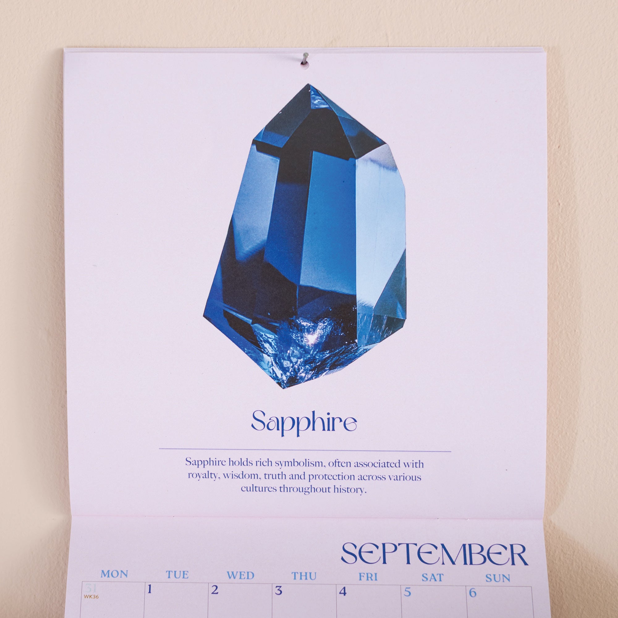 Calendar page with a blue sapphire gemstone and September.