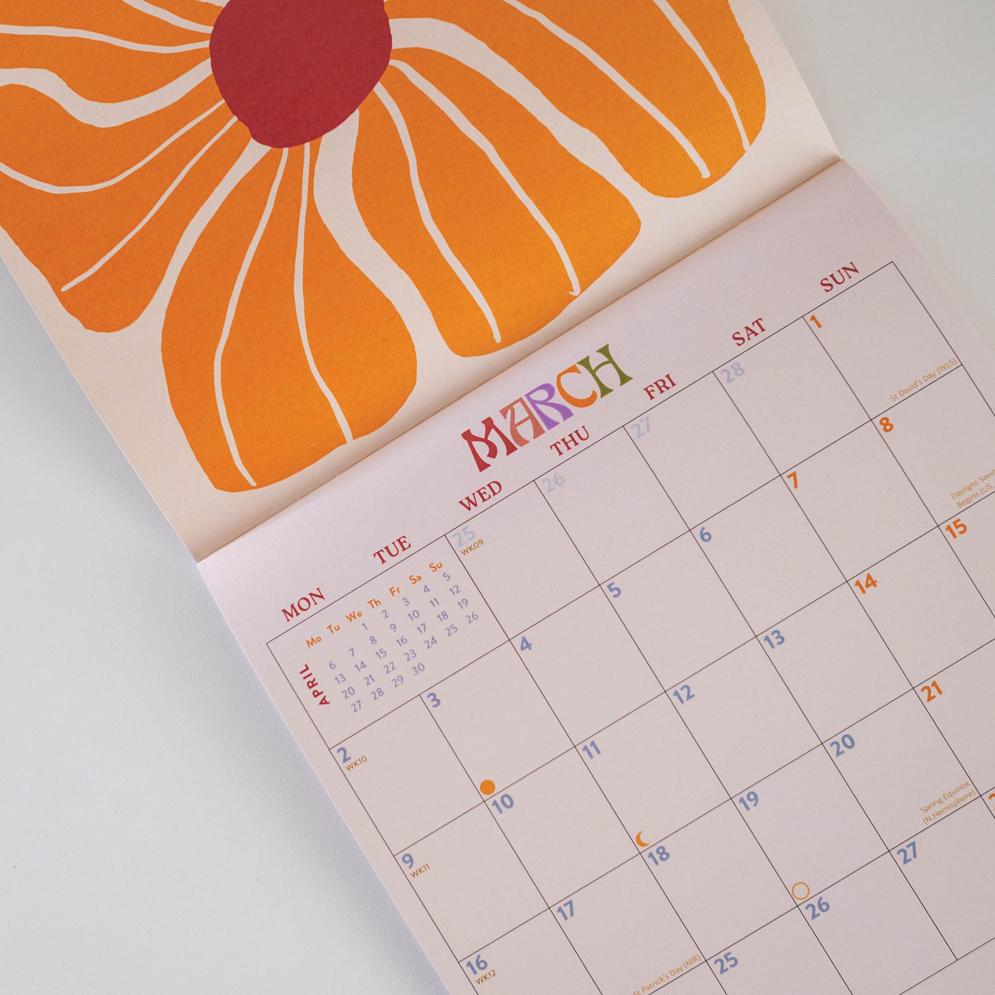 2026 Wall calendar with bright floral design. Showing the month of March with Orange flower design. 