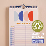 Calendar with November layout, colorful abstract design, and recycled paper label on a beige background