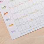 2027 Calendar sheet with colorful month labels. Wall planner made on recycled paper.