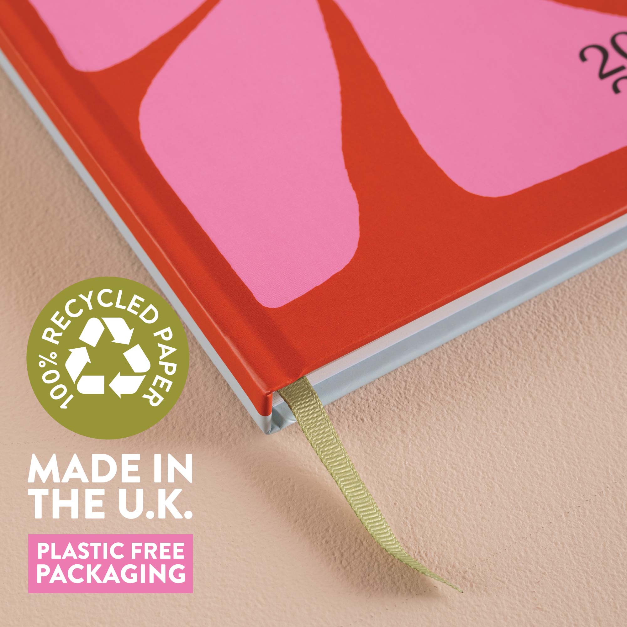 2026 Diary with a pink abstract design on a red cover, featuring a recycled paper label and text about UK manufacturing and plastic-free packaging.
