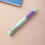 A multiclick turquoise pen with a purple rubber grip