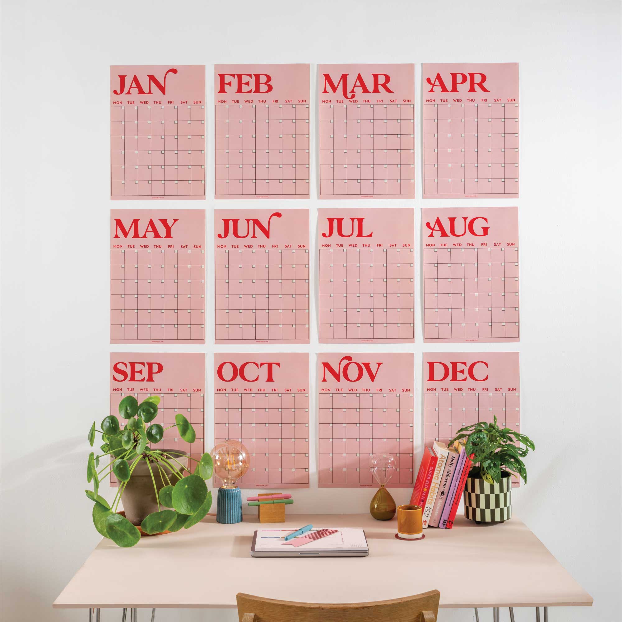 Large Monthly Undated A3 Wall Planner – 12 pink and red monthly pages displayed on a wall above a desk with decorative items