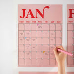 Close-up of January page from the pink and red A3 wall planner, featuring bold typography and handwritten notes