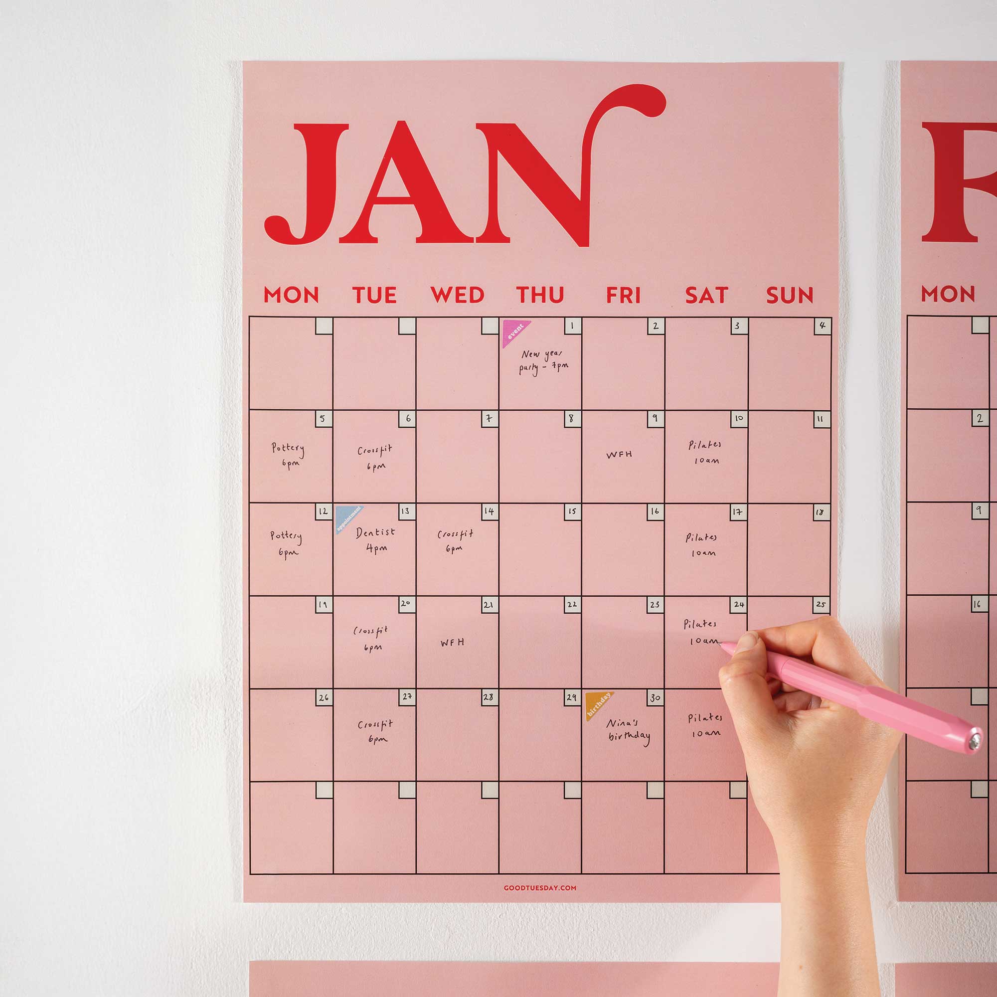 Close-up of January page from the pink and red A3 wall planner, featuring bold typography and handwritten notes