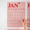 Close-up of January page from the pink and red A3 wall planner, featuring bold typography and handwritten notes