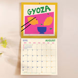 Inside of the Dishes around the World 2026 calendar. Large monthly grid with week numbers, bank holidays, and lunar phases.