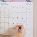 Close up of the Folk Animals 2026 calendar in use, showing the planner in use. Large monthly grid with week numbers, bank holidays, and lunar phases.