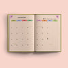 An open 2026 diary showing a detailed calendar view for January. It includes days of the week, dates, and icons for moon phases, along with specific holiday entries like New Year's Day and Burns Night.
