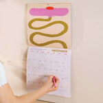 Close up of Les Fleurs 2026 calendar, showing the planner in use. Large monthly grid with week numbers, bank holidays, and lunar phases.