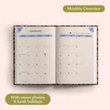 Open planner showing month-to-view January 2027 with moon phases and bank holidays on a pink background.