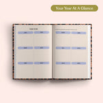 Open planner with 2027 year-to-view on a pink background. B Corp. Year Planner.