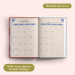 Open planner showing month-to-view January 2027 with moon phases and bank holidays on a pink background.