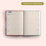 Open planner showing a weekly view with notes on a pink background. Recycled Paper.