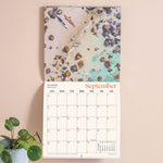 Month to view page of 2027 calendar with large date grid and hand-painted ocean scene