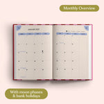 Open planner showing month-to-view January 2027 with moon phases and bank holidays on a pink background.