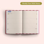 Open planner showing a weekly view with notes on a pink background. Recycled Paper.