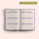 Open planner with 2027 year-to-view on a pink background. B Corp. Year Planner.