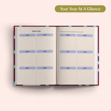 Open planner with 2027 year-to-view on a pink background. B Corp. Year Planner.