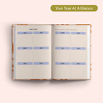 Open planner with 2027 year-to-view on a pink background. B Corp. Year Planner.