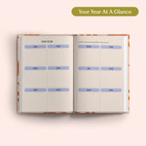 Open planner with 2027 year-to-view on a pink background. B Corp. Year Planner.