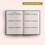 Open planner with 2027 year-to-view on a pink background. B Corp. Year Planner.