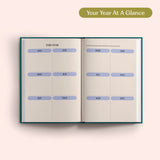 Open planner with 2027 year-to-view on a pink background. B Corp. Year Planner.