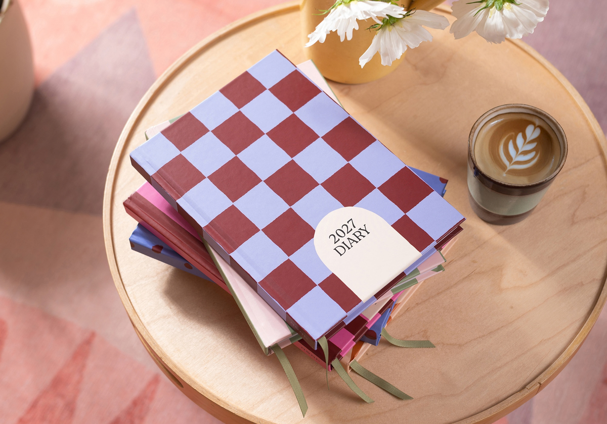 2027 blueberry check diary by Good Tuesday set up on a coffee table with a morning coffee with flowers