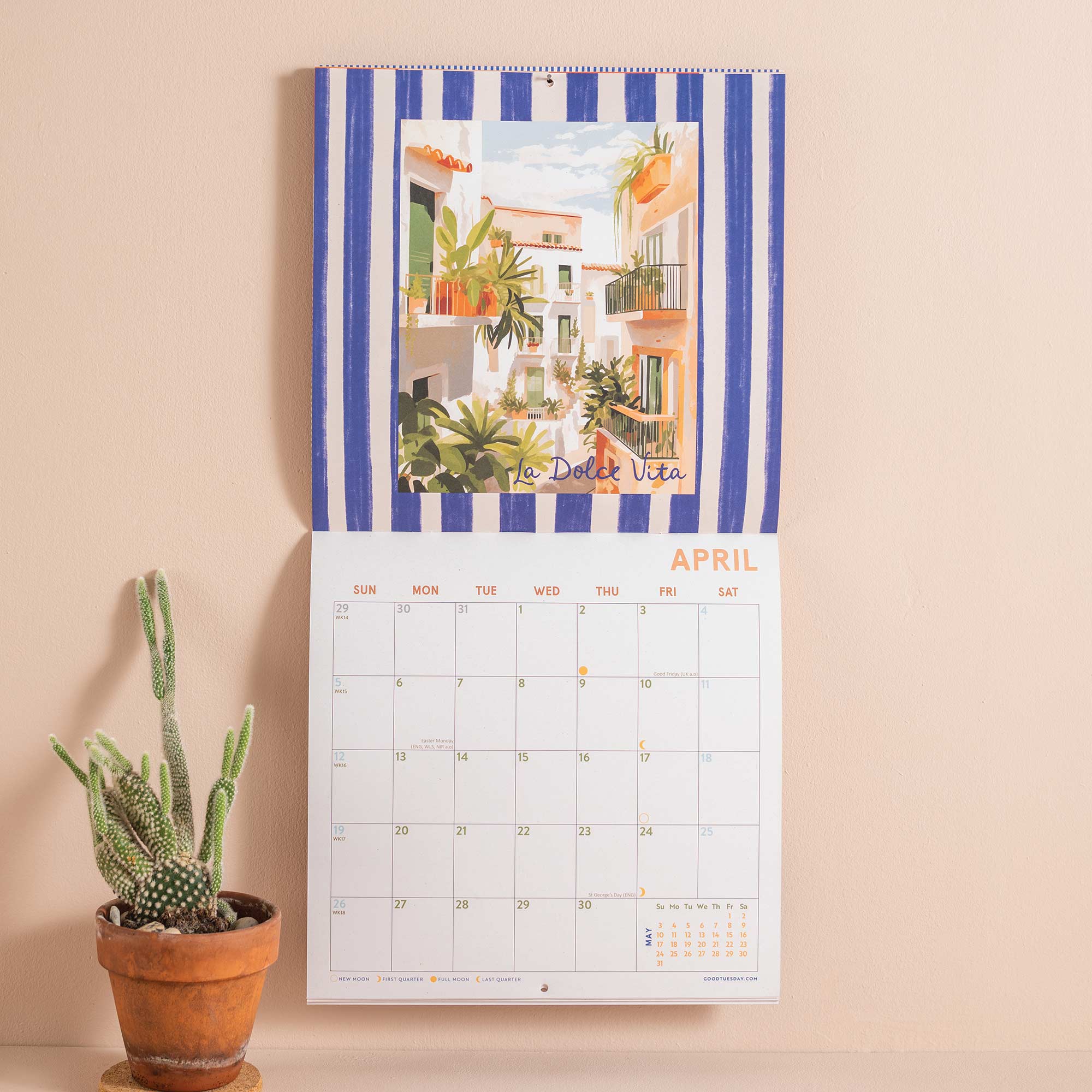 Wall calendar with blue and white striped border and 'La Dolce Vita' theme, featuring a potted plant on a beige background.