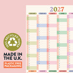 2027 calendar with pastel colors on a pink background, featuring recycled paper and plastic-free packaging text.