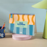 Spiral bound academic desk calendar standing upright with monthly overview