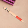 Orange multiclick erasable pen on a beige surface with a striped object in the background.
