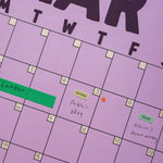 Purple calendar with handwritten notes and stickers on a purple background