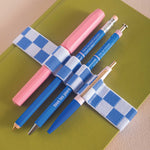 Blue and white checkered bookband, holds 4 pens
