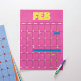 Pink calendar sheet with February dates on a white background