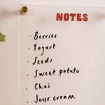 Acrylic wipeable notepad mounted on wall in use for weekly planning and notes
