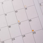 Close-up of a calendar with dates and markers.