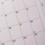 Close-up of a calendar with dates and markers.
