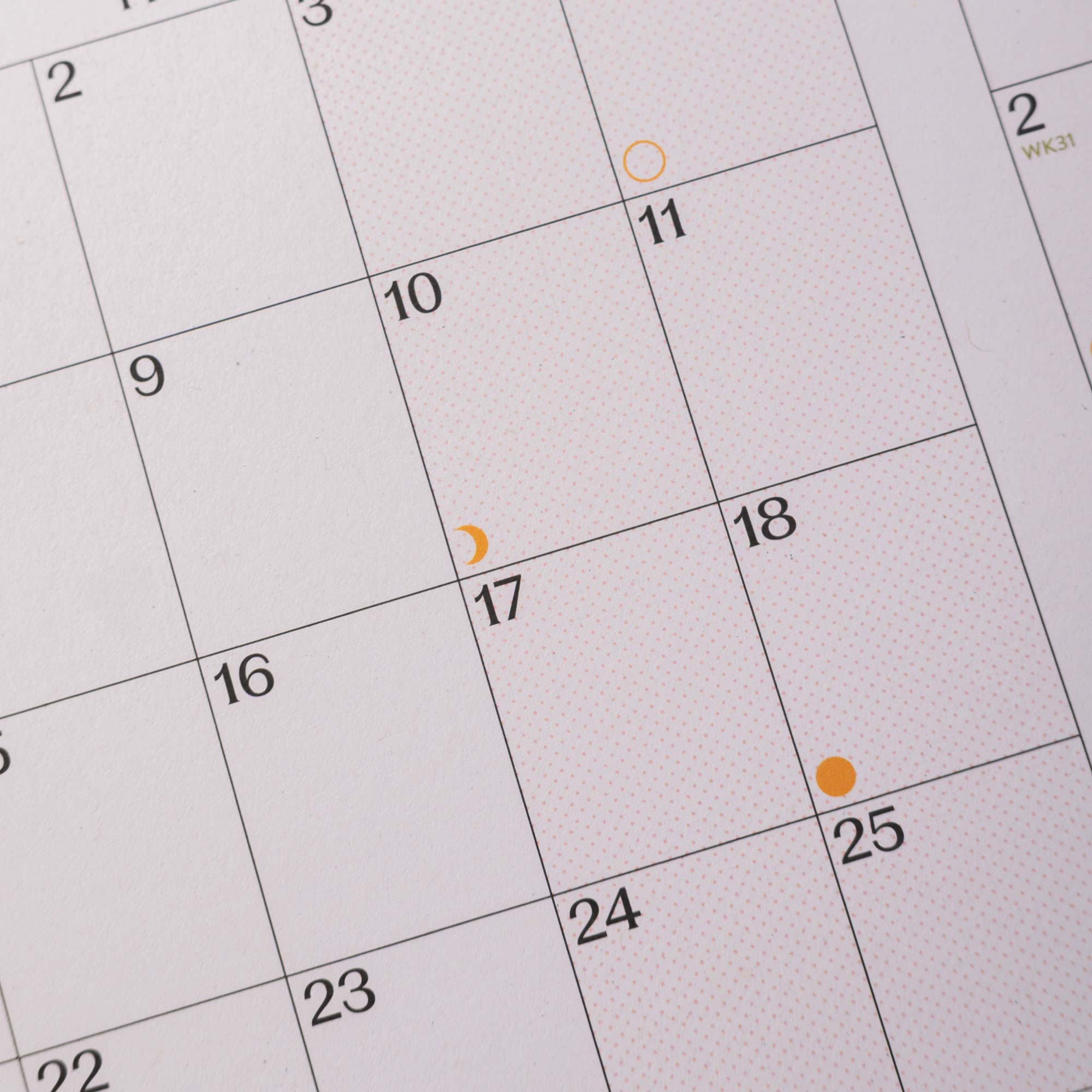 Close-up of a calendar with dates and markers.