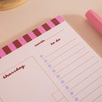 A4 Checks & Stripes Weekly Planner Pad shown on a desk alongside stationery