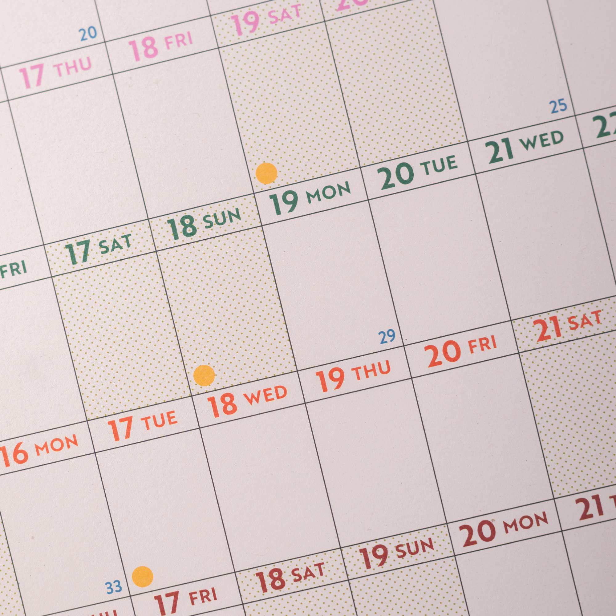 Calendar with dates highlighted in different colors on a light gray background