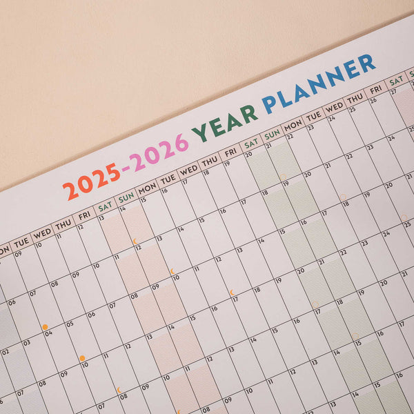 close up of academic wall planner showing highlighted weekends and moon phases