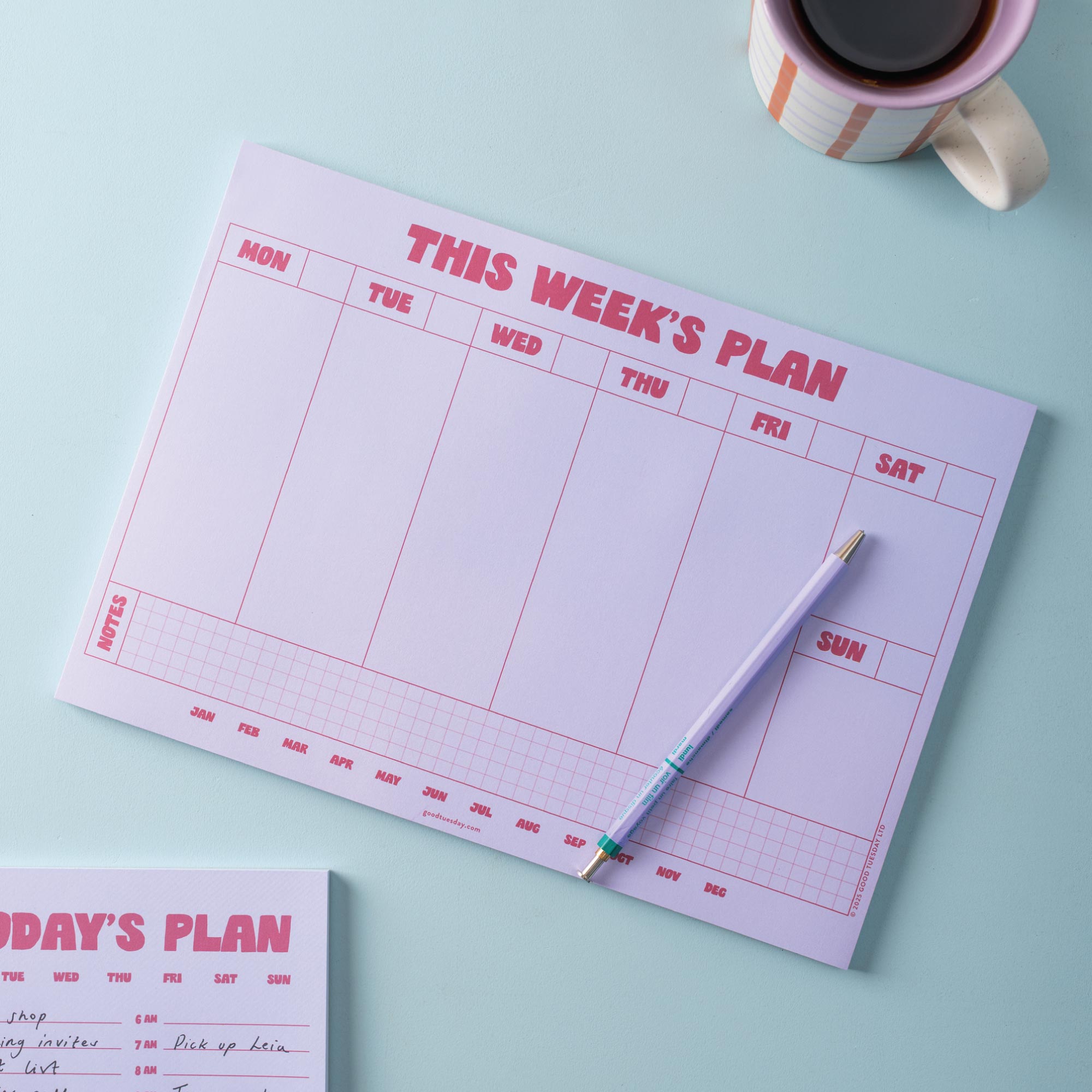 Weekly planner with a pen and coffee cup on a light blue background